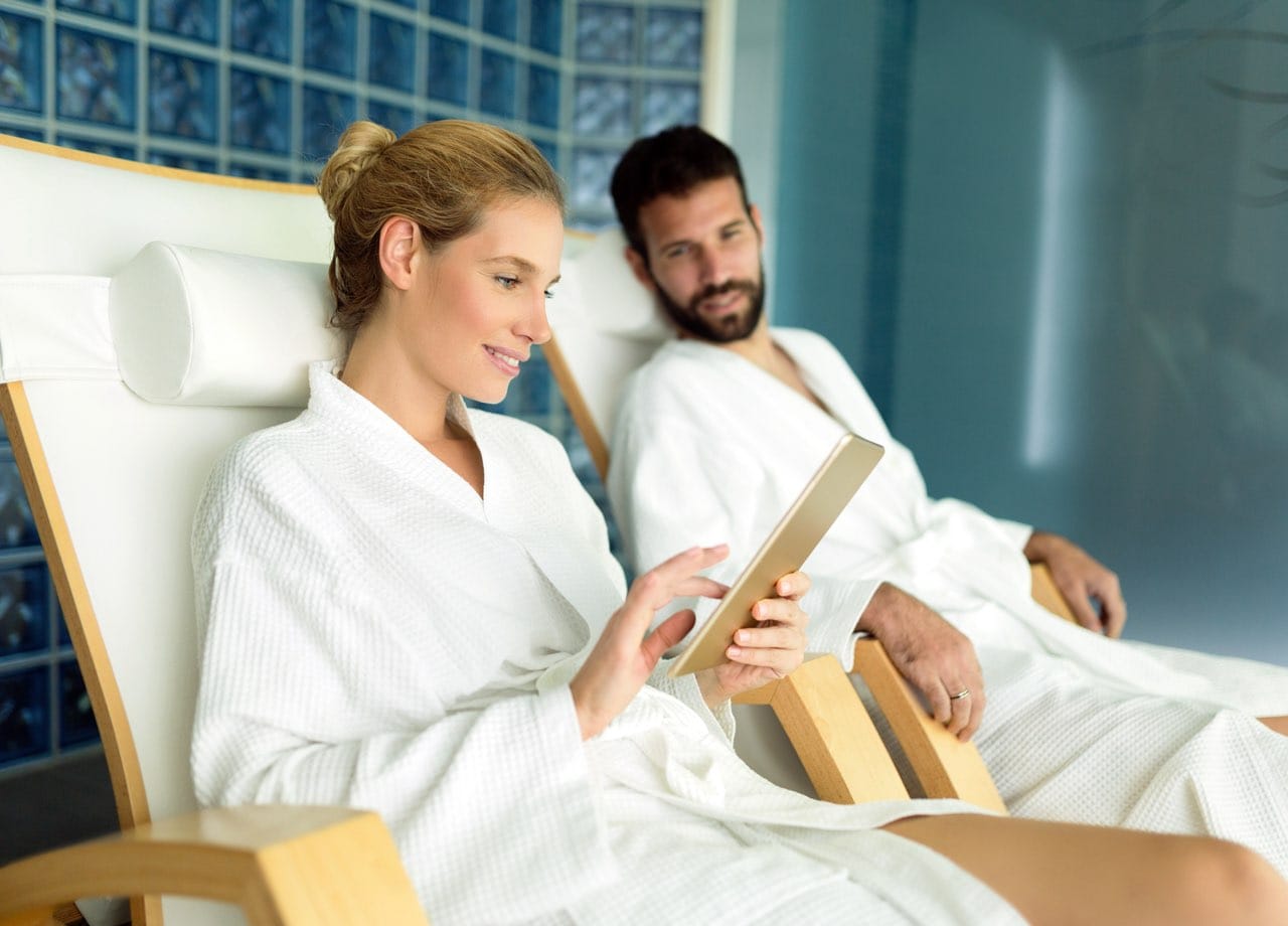 Happy young couple relaxing in spa center together